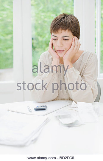 woman-paying-bills-and-looking-worried-b