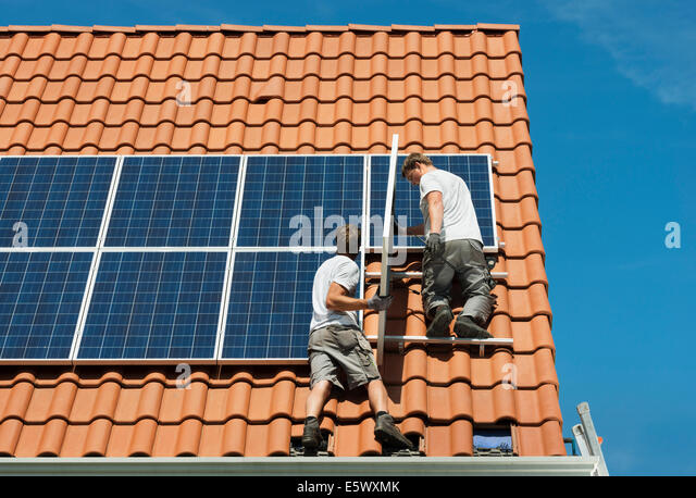 workers-installing-solar-panels-on-roof-