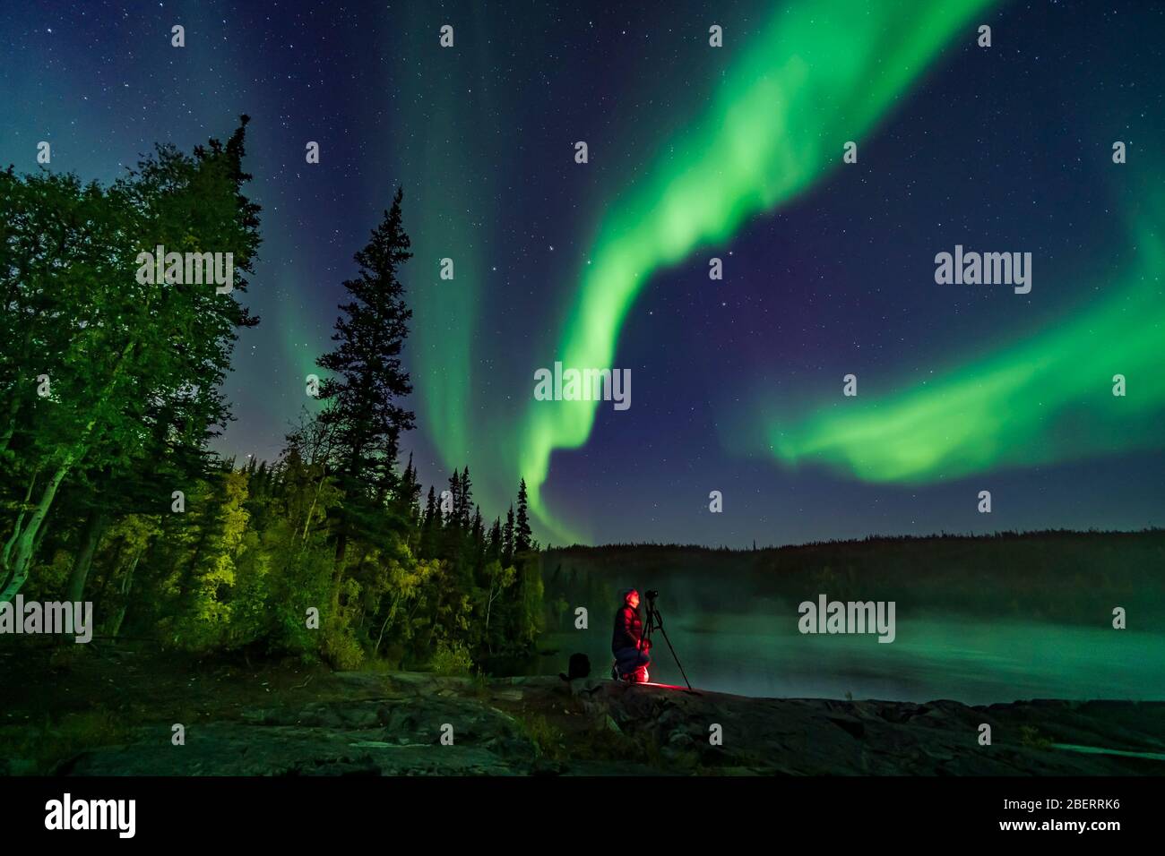 Photographer Shooting The Northern Lights On The Cameron River In