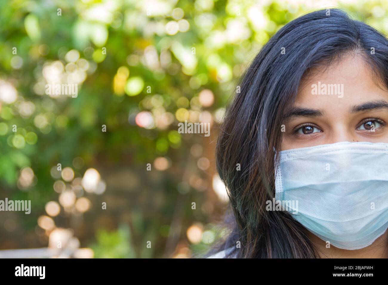 half face portrait of an indian girl wearing a face mask during covid ...
