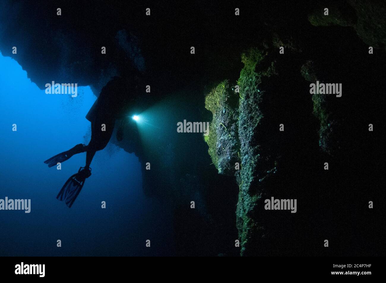 Scuba diver explores the stalactites inside the Great Blue Hole, a ...