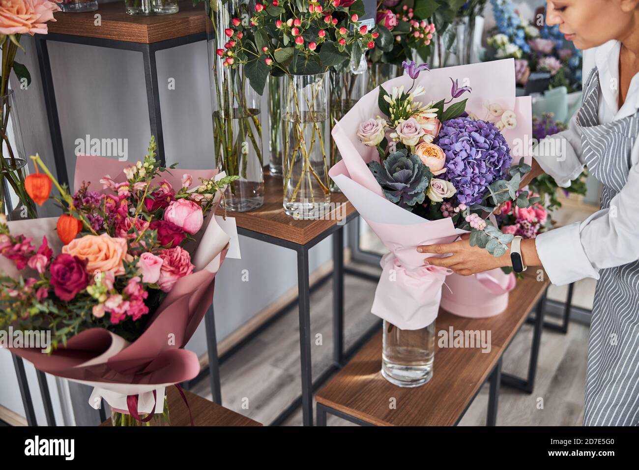 Responsible flower shop worker taking care of flower bouquets Stock ...