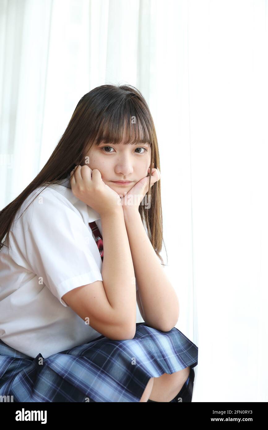 Portrait japanese school girl uniform sitting and look at camera in ...