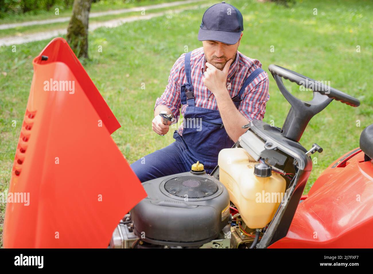 One man repairing broken lawn mower engine in the garden Stock Photo ...
