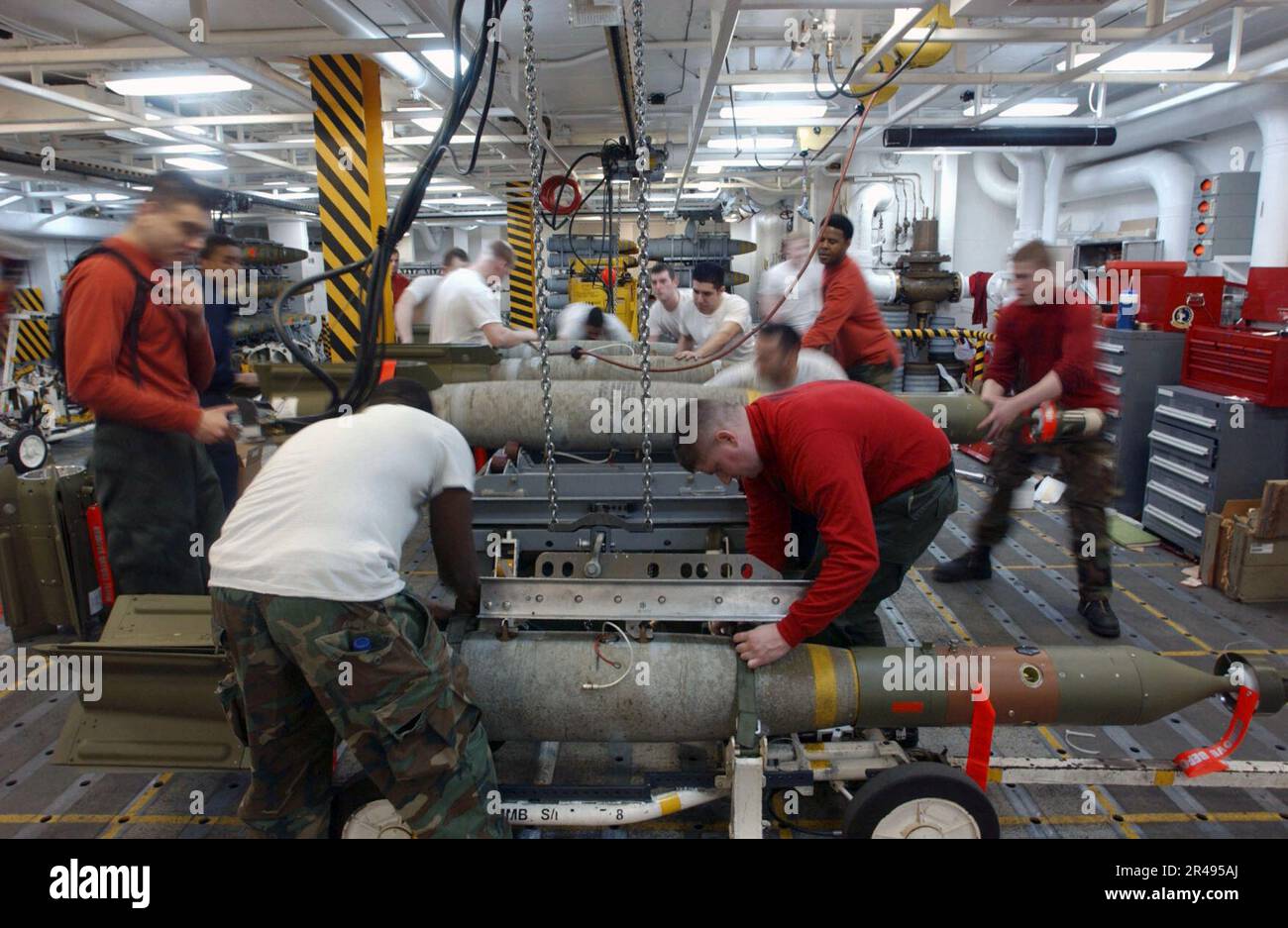 US Navy Aviation Ordnancemen assemble and move ordnance in a weapon's ...