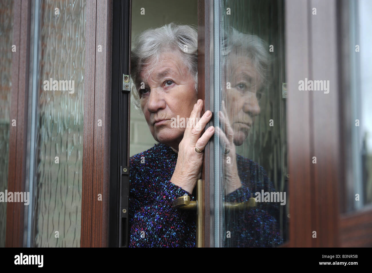 WORRIED ELDERLY LADY LOOKING AROUND HER FRONT DOOR,UK Stock Photo - Alamy