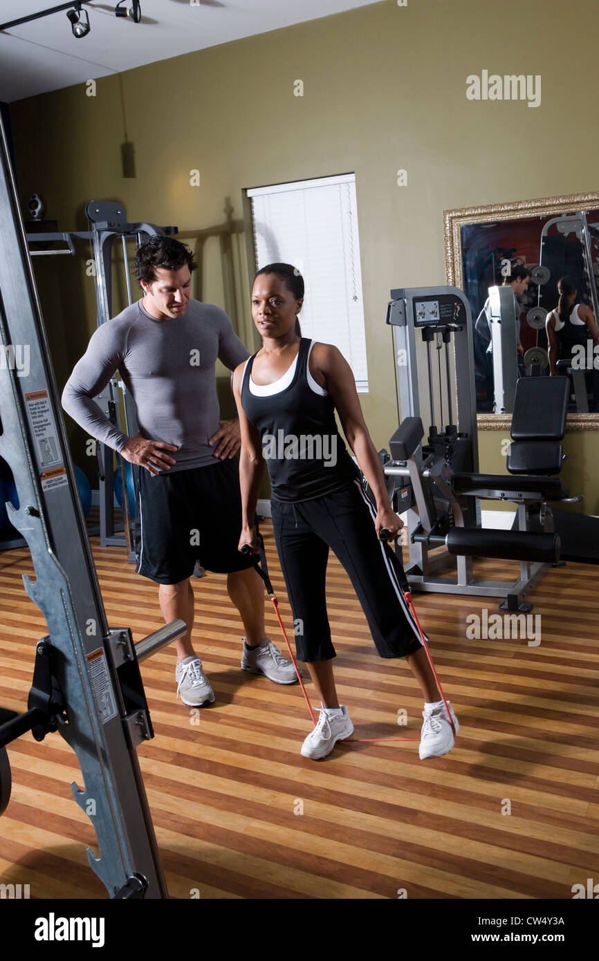 Trainer Instructing A Young Woman In The Gym Stock Photo Alamy
