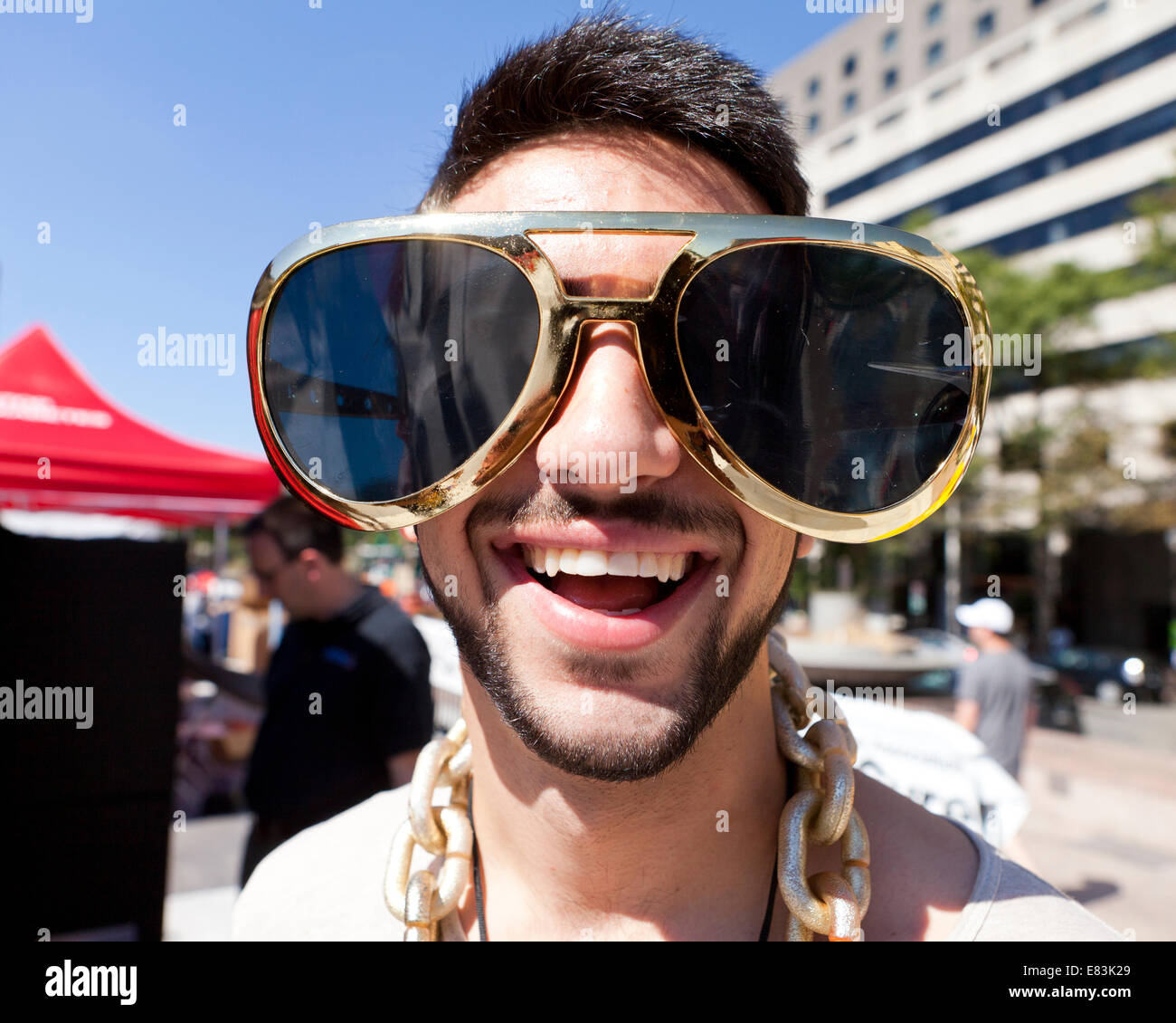 Young man wearing funny oversize novelty sunglasses - USA Stock