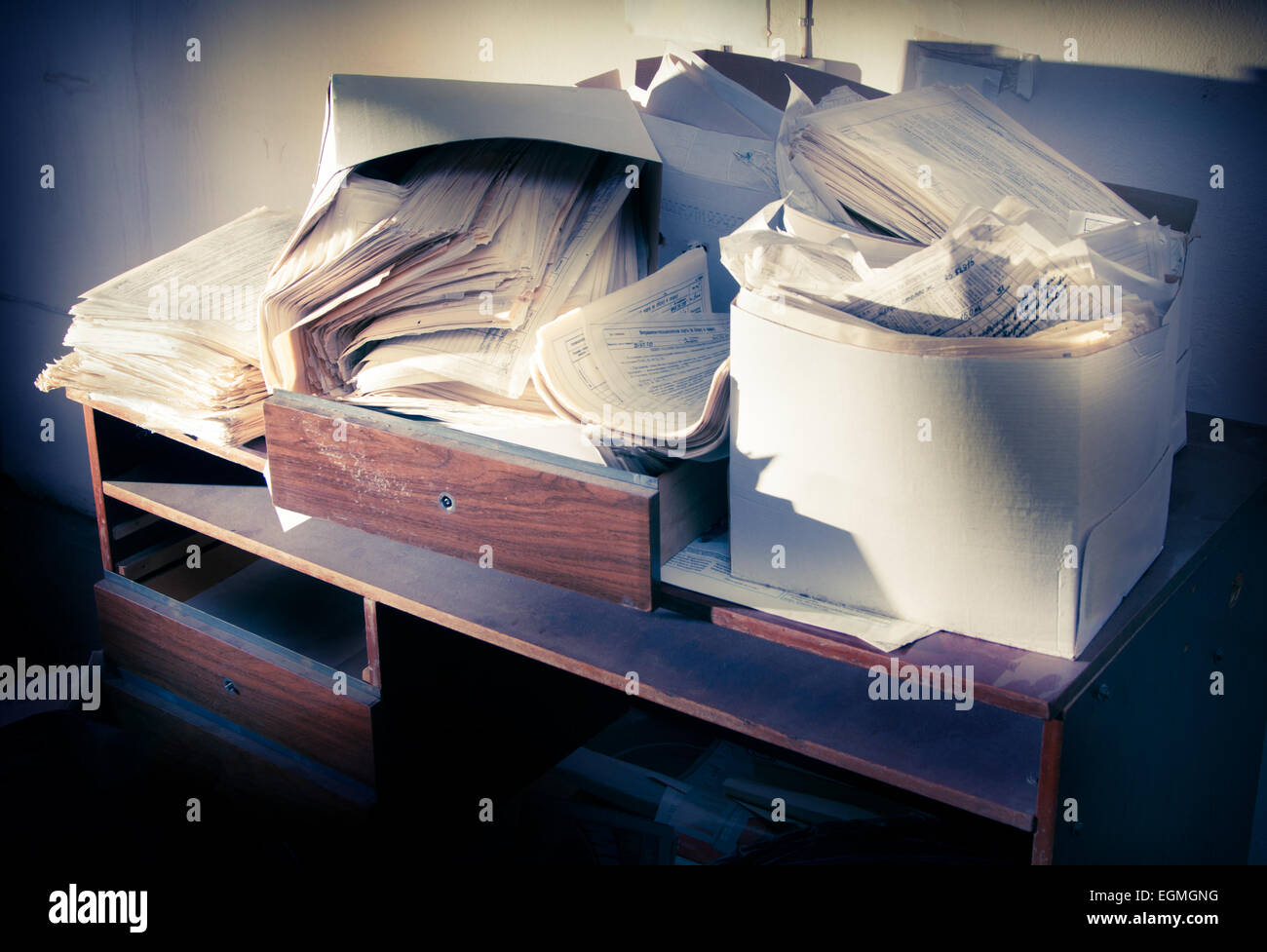 Messy workplace with table and stack of paper Stock Photo - Alamy
