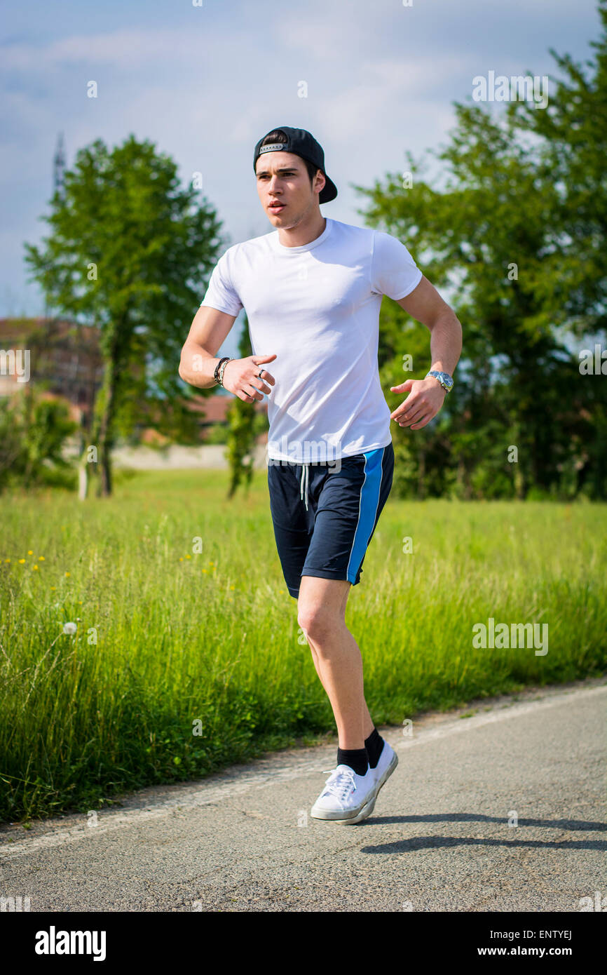 Handsome Young Man Running And Jogging On Road In The Country In A