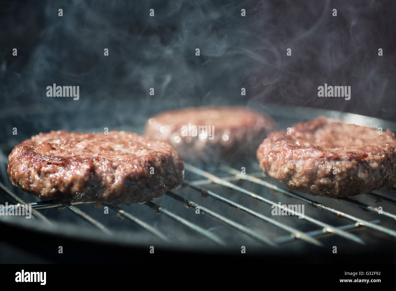 Burgers cooking on a Barbecue Stock Photo - Alamy