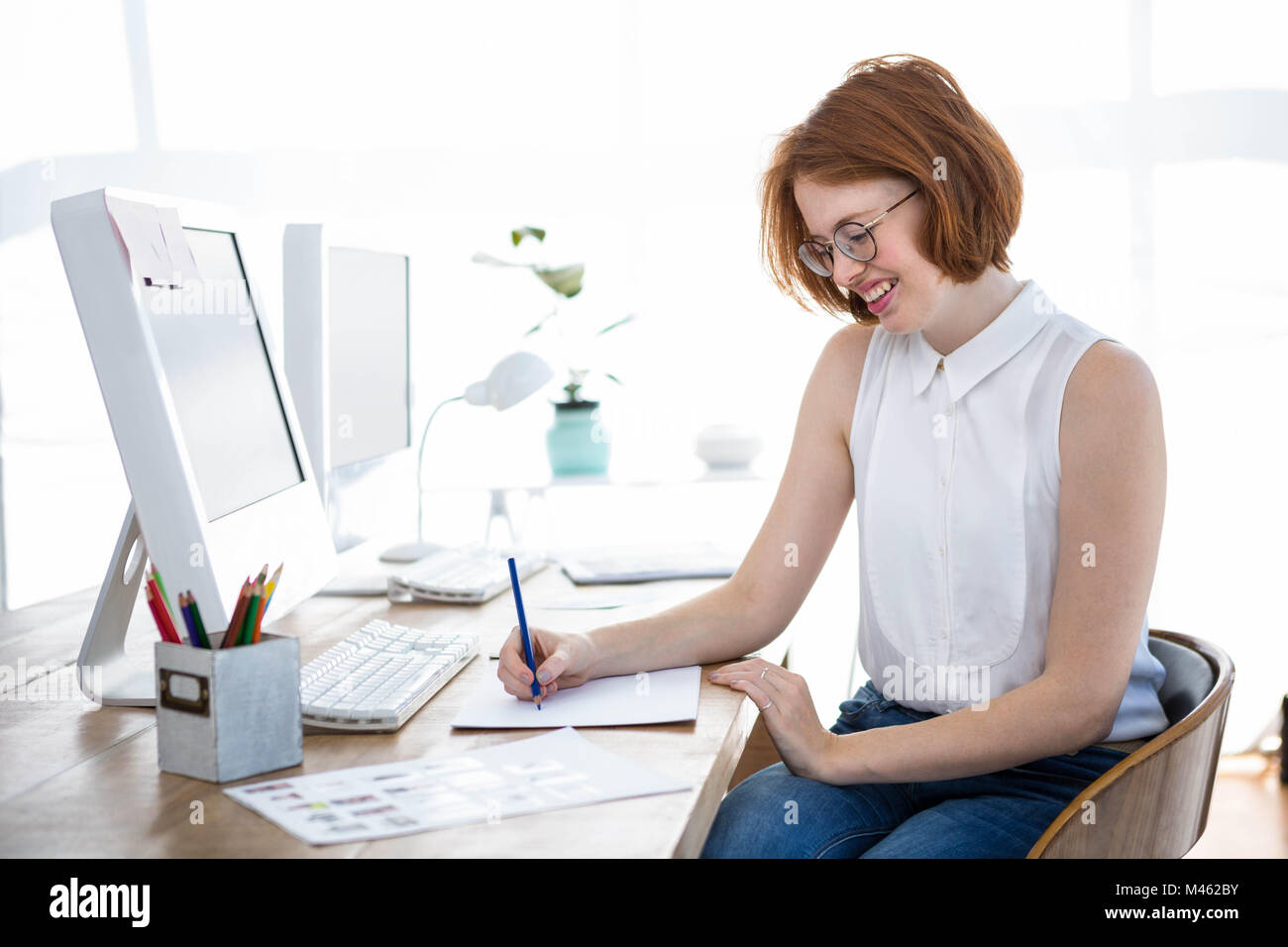 smiling hipster businesswoman sketching at her desk Stock Photo - Alamy