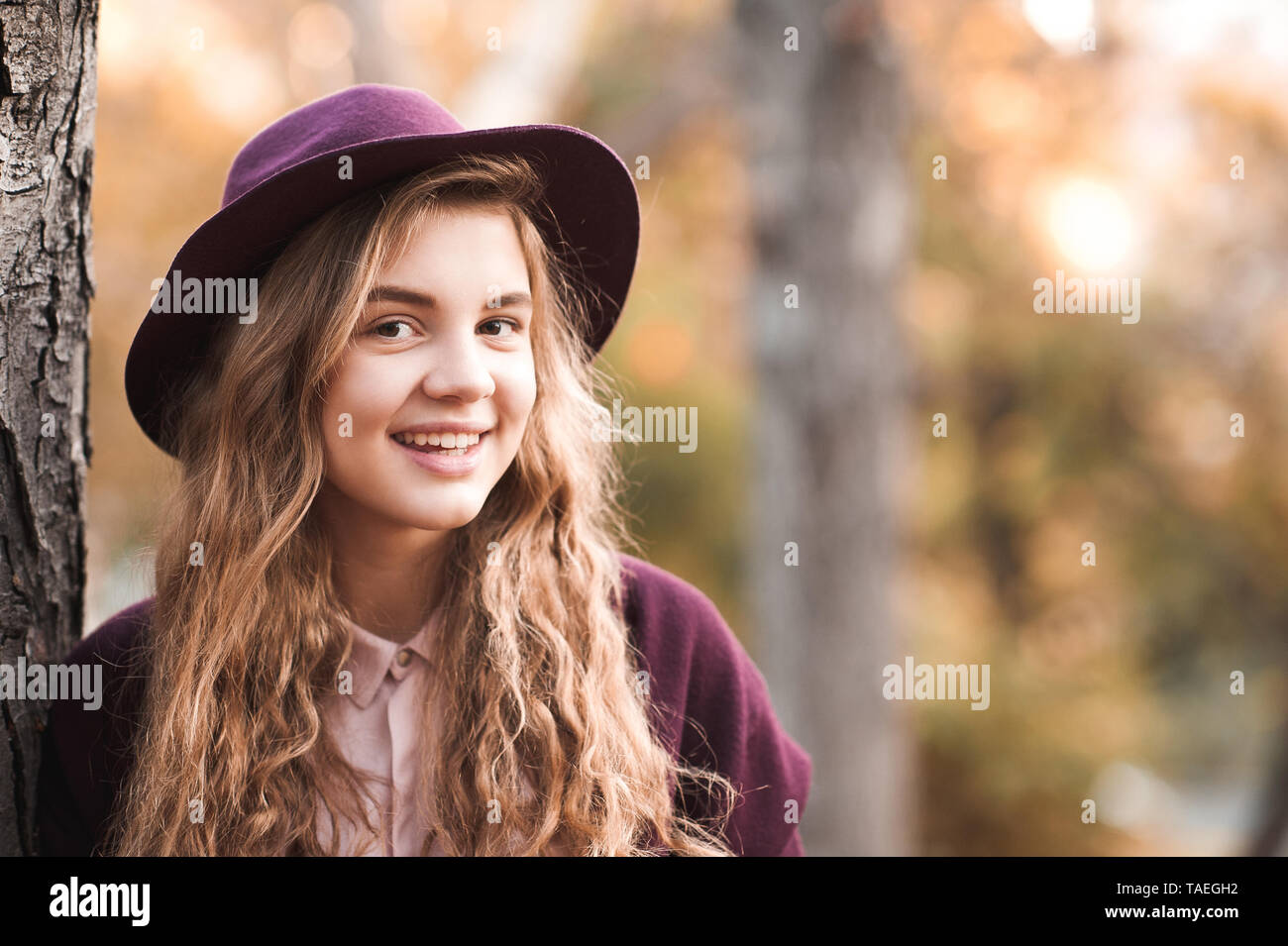 Smiling Teenage Girl 14 16 Year Old Wearing Stylish Felt Hat Posing In Park Looking At Camera 