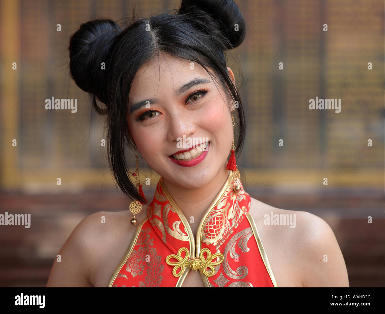 Young Thai Chinese beauty with Chun Li double hair buns wears a stylish ...