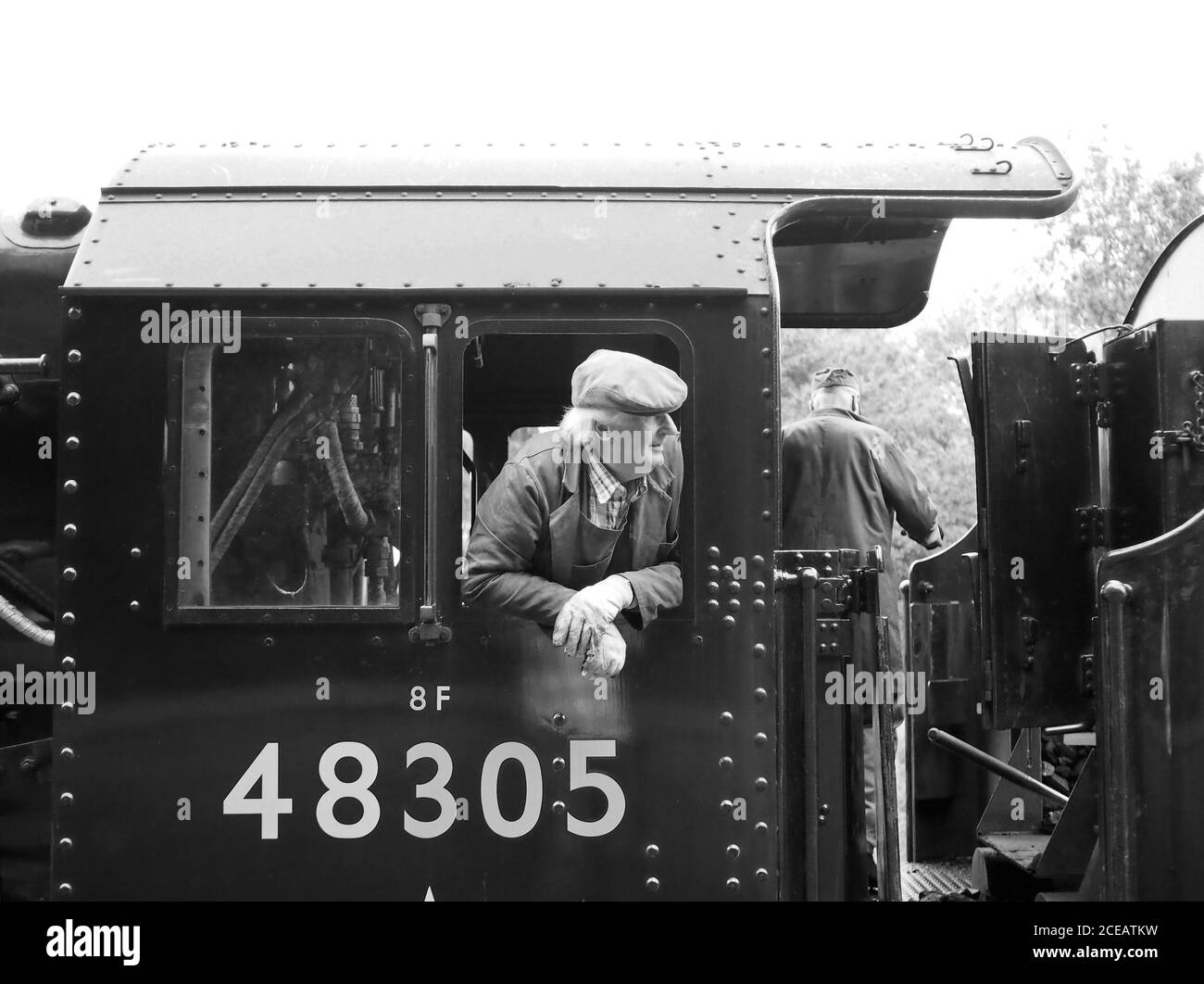 Driver leaning out of the cab of 48395, a Stanier LMS 8F Class 2-8-0 ...
