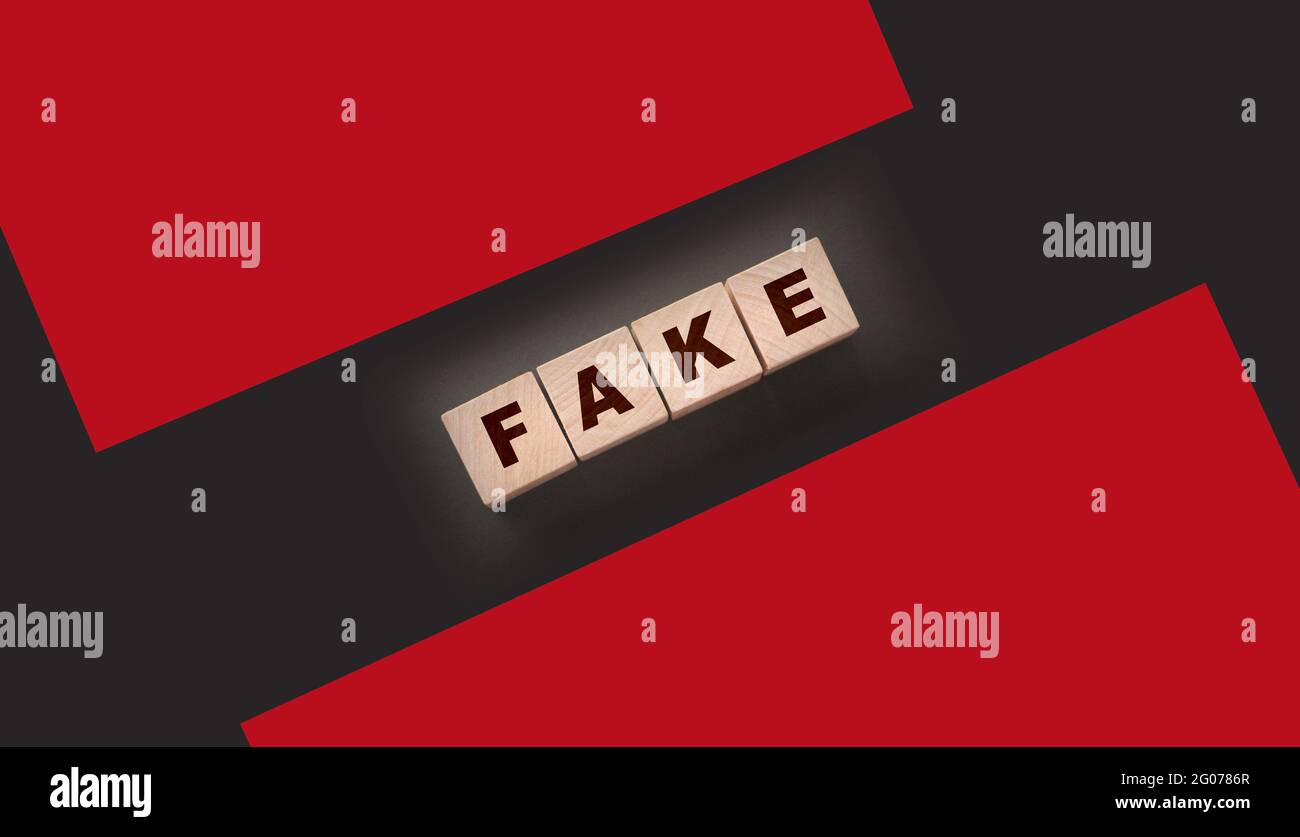 FAKE word written in wooden blocks on black Stock Photo - Alamy