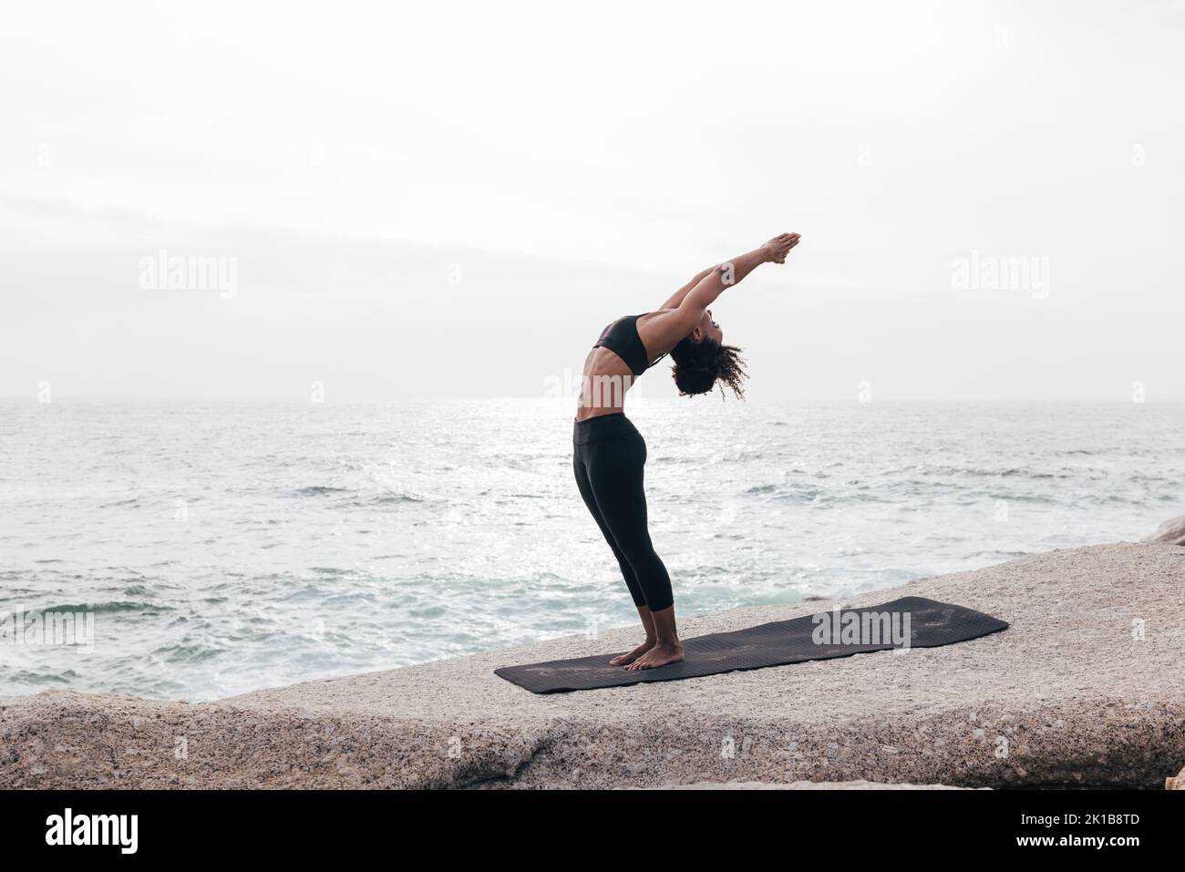 Woman in Standing Backbend Pose by ocean Stock Photo - Alamy