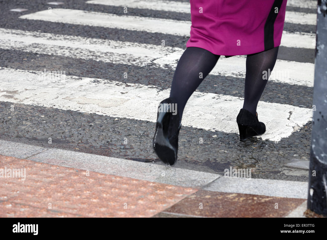 business woman walking over textured pedestrian crossing pavement in ...