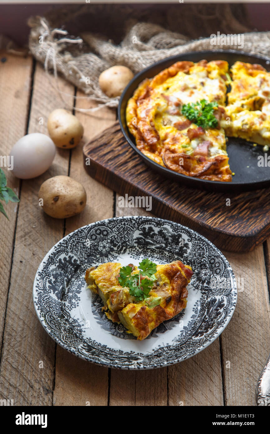 A piece of french baked omelette Savoy with ham, cheese, potato and ...