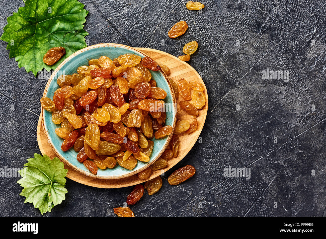 Yellow big raisins on black concrete background with copy space. Top ...