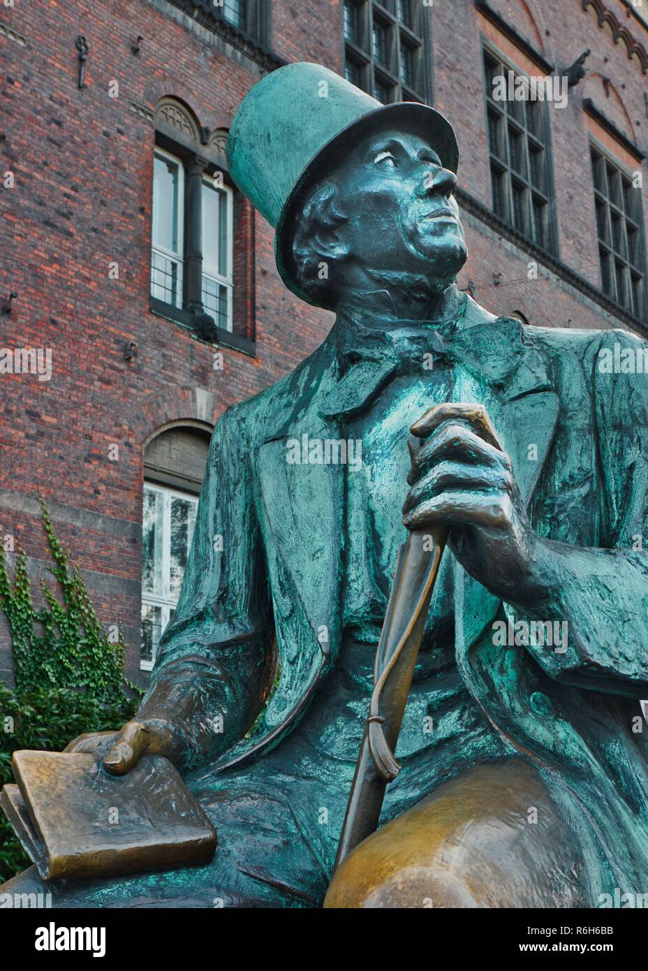 Bronze seated statue of Hans Christian Andersen holding a book ...