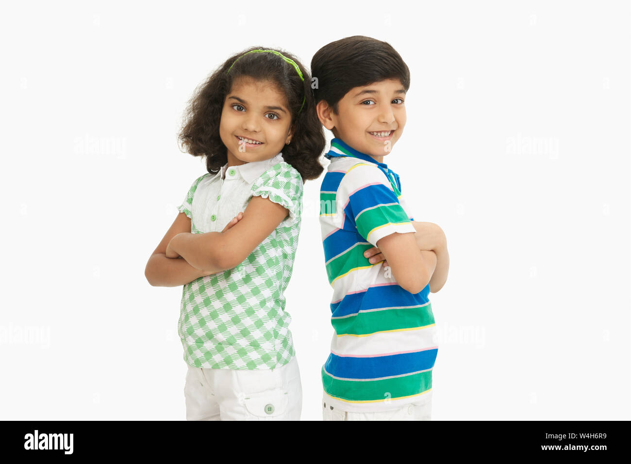 Two children standing back to back and smiling Stock Photo - Alamy