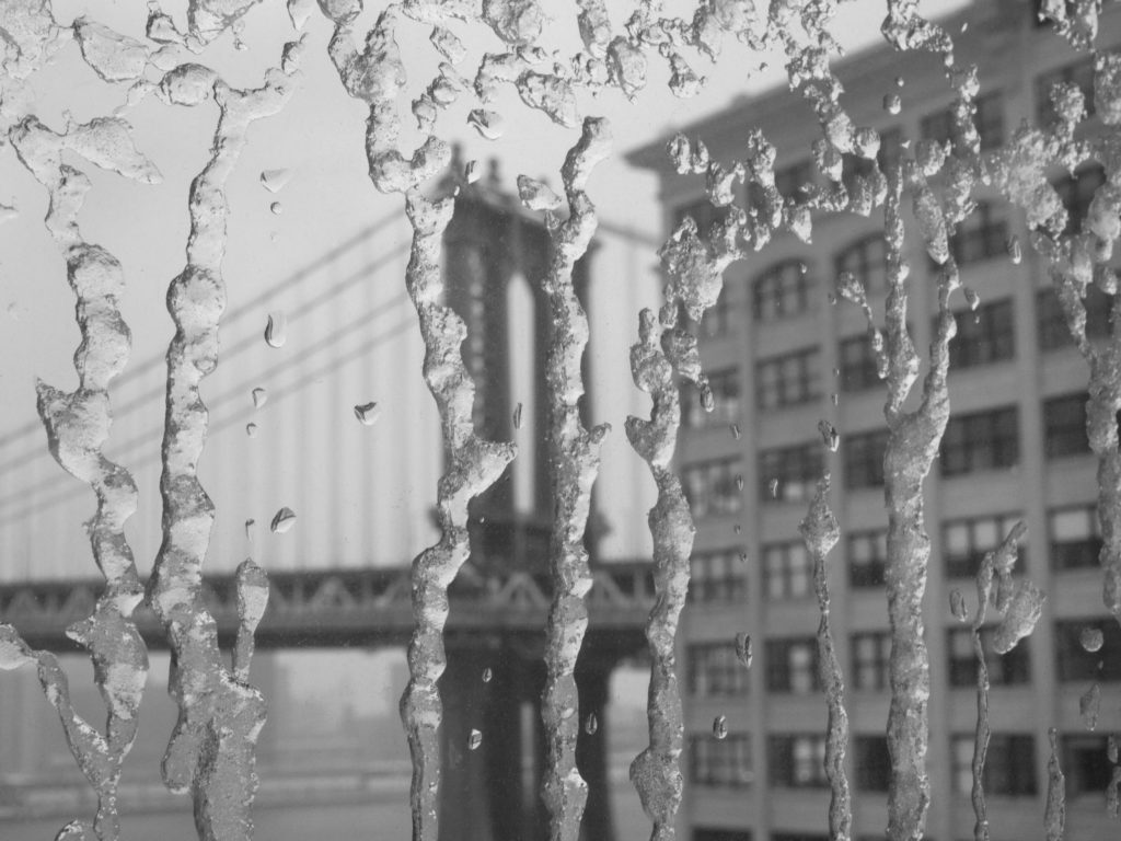 Frozen ice drips on window.
