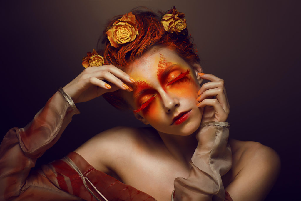 Bodyart. Imagination. Artistic Woman with Red - Gold Makeup and Flowers. Coloring
